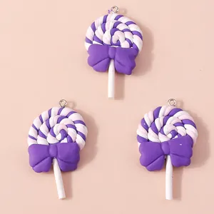 Makro-Detail von drei Harz-Lollipop-Anhängern mit lila Schleifen für DIY-Bastelarbeiten