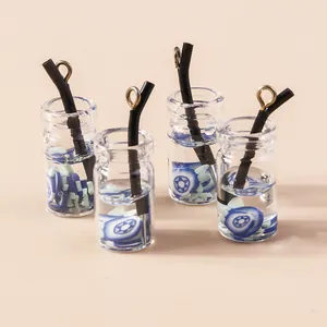 Dettaglio di mini ciondoli a forma di tazza di tè con glitter blu per gioielli fai da te