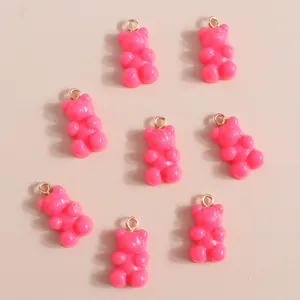 Close-up of pink resin bear charms with golden rings for DIY jewelry making