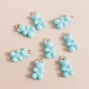 Macro shot of 7 light blue resin bear charms with metal jump rings for DIY jewelry making