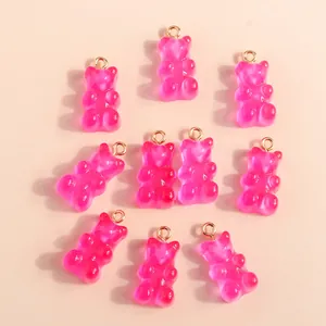 Flat lay of translucent pink resin bear charms with gold loops for DIY jewelry making