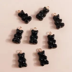 Close-up of glossy black resin bear charms with golden loops for DIY jewelry making