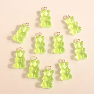 Macro view of light green gummy bear resin charms with golden hanging loops for DIY crafts