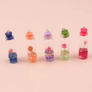 Row of five colorful mini glass bottle pendants with dried flowers and metal rings