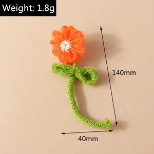 Detail showing an orange hand-knitted flower with green stem and leaf, 140mm height