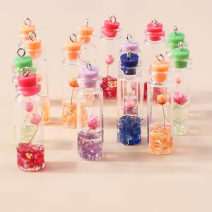 Miniature glass drift bottle charms with dried flowers and colorful stoppers for DIY crafts