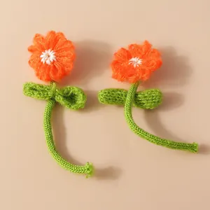 Handmade knitted flowers with orange petals and green stems for DIY bag accessories