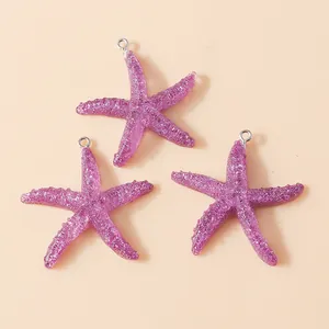 Macro detail of three purple resin starfish charms with silver hanging loops for DIY jewelry