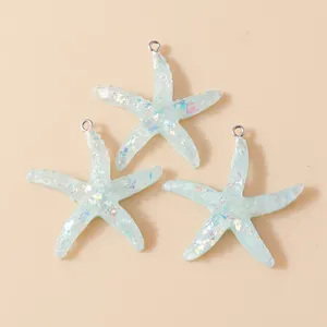 Detailed view of light blue resin starfish pendants with iridescent sequins and metal rings