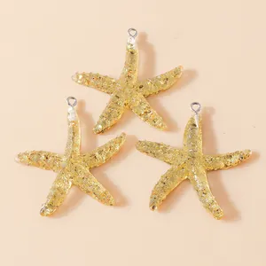 Detail of three resin starfish charms filled with gold leaf and silver link rings