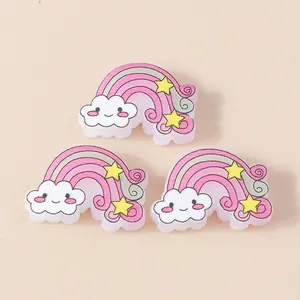 Macro detail of resin rainbow and cloud charms for DIY hair accessories and craft decor