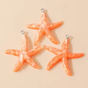 Three orange resin starfish pendants with glitter texture and silver rings for DIY jewelry