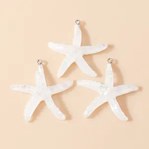 Macro detail of translucent resin starfish charms with iridescent glitter and metal loops