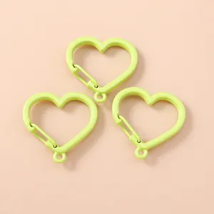 Tre moschettoni a forma di cuore in verde lime vibrante per la creazione di gioielli fai da te