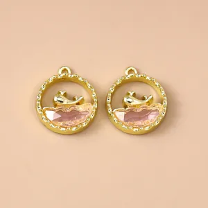 Gedetailleerd beeld van gouden walvisbedels met roze kristal voor het maken van sieraden