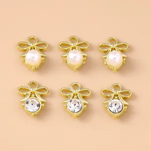 Detail of bow charms with pearls and rhinestones in gold finish for DIY jewelry