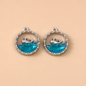 Macro detail van zilveren walvis hangers in blauwe oceaan hars voor sieraden