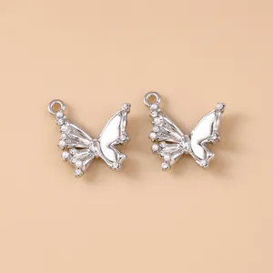 Detailed macro view of silver butterfly pendants with white pearls and sparkling rhinestones