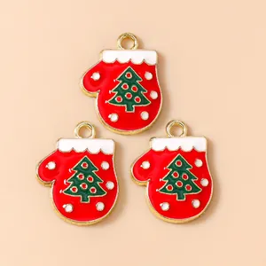 Detalle de colgantes de guantes rojos de Navidad con árbol verde para bisutería DIY