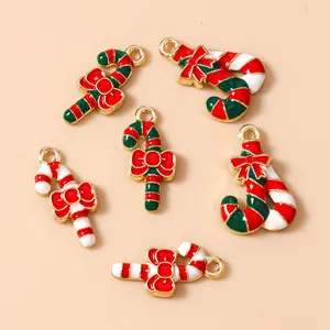 Detailed view of red and white Christmas candy cane charms with gold bows for DIY crafts