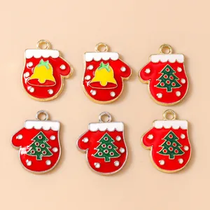 Detalle de colgantes de guantes navideños de esmalte rojo con motivos de campana y árbol