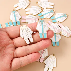 Detalle de dijes esmaltados con forma de batas médicas para joyería DIY y llaveros