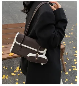 Détail d'un sac à bandoulière marron foncé avec bordure en polaire et un petit porte-monnaie