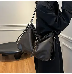 Detail view of large dark brown leather tote bag with vintage gold hardware and soft texture