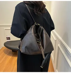 Detail of dark brown tote bag on model showing large capacity and soft oil finish