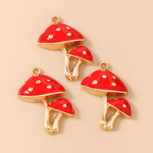 Vista macro de dijes de champiñón en esmalte rojo y dorado para joyería creativa