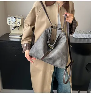 Detail of vintage grey tote bag with adjustable brown leather straps and metal hardware