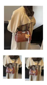 Gros plan sur le sac Kelly rétro marron en cuir texturé avec boucle et décoration foulard