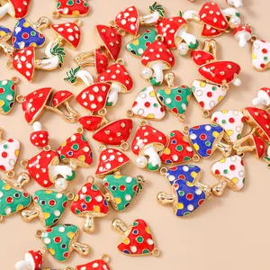 Detalle de colgantes de setas esmaltadas de colores con perlas y aros dorados