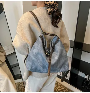 Detail showing vintage blue tote bag textured fabric with brown leather straps