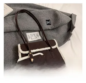 Détail du sac à bandoulière mat marron foncé avec bordure en peau lainée blanche et lanières