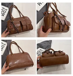 Detail of brown vintage Boston bag with front buckle pockets and smooth leather texture