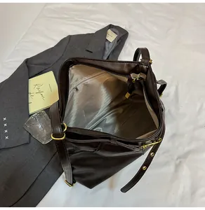 Detail view of the brown tote bag inner lining with a zipper pocket and golden hardware