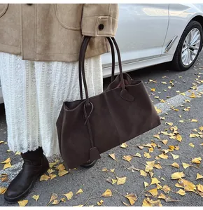Dettaglio borsa tote in pelle scamosciata marrone scuro con spalline sottili
