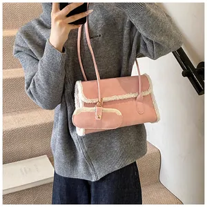 Détail du sac à bandoulière en suédine rose avec bordure en peau de mouton et mini pochette