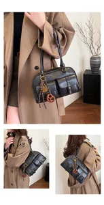 Detailed view of dark retro Boston bag with double pockets and gold hardware