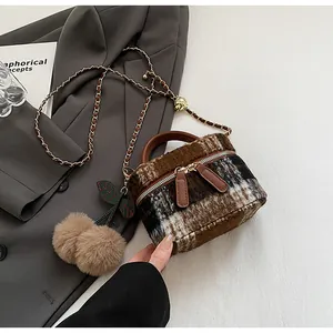 Detail van de getextureerde tweed mini-emmer tas met leren handvat en metalen ketting
