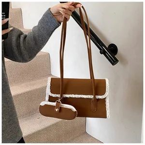 Détails de ce sac à bandoulière en daim marron avec bordure en fourrure synthétique blanche