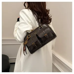 Detail of vintage coffee brown shoulder bag with dual front pockets and metal buckle hardware