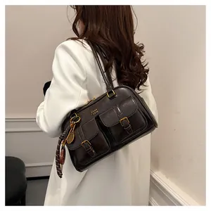 Detail of vintage brown Boston bag with double buckle pockets and decorative scarf