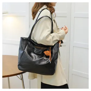 Dettaglio della borsa tote in ecopelle nera con logo TanTan e ciondolo a forma di orso