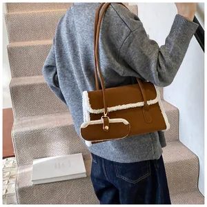 Détail d'un sac à bandoulière marron avec bordure en peau lainée blanche et mini pochette