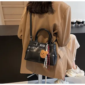 Détail d'un sac à main noir avec coutures blanches contrastées et boucle en métal argent
