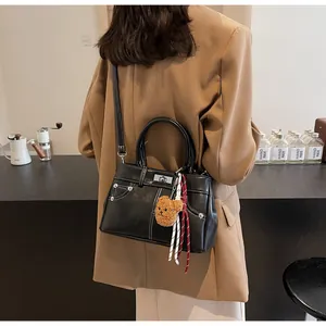 Détail du sac style Kelly noir avec pendentif ours décoratif sur vue de dos