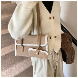 Gros plan du sac beige avec bordure en fausse fourrure blanche et mini pochette assortie
