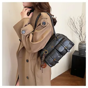 Detail of vintage black Boston bag featuring double front pockets and gold logo accent